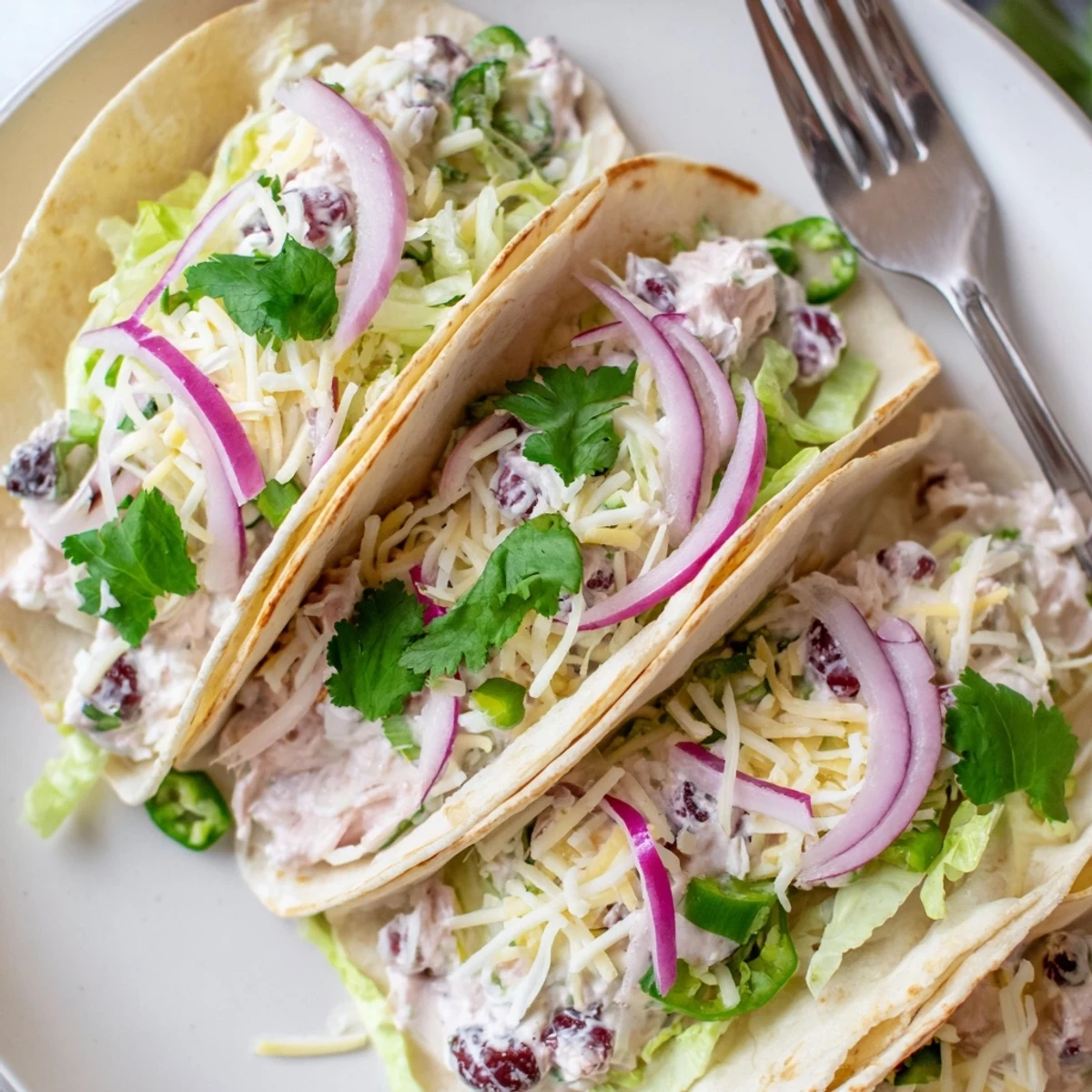 Creamy cranberry jalapeño dip tacos topped with fresh lettuce and cheese.  