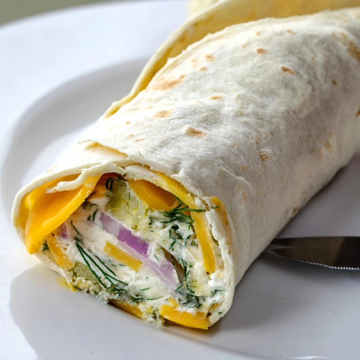 Crispy pickles wrapped in tortillas with creamy cheese for the Pickle-in-a-Blanket recipe.  