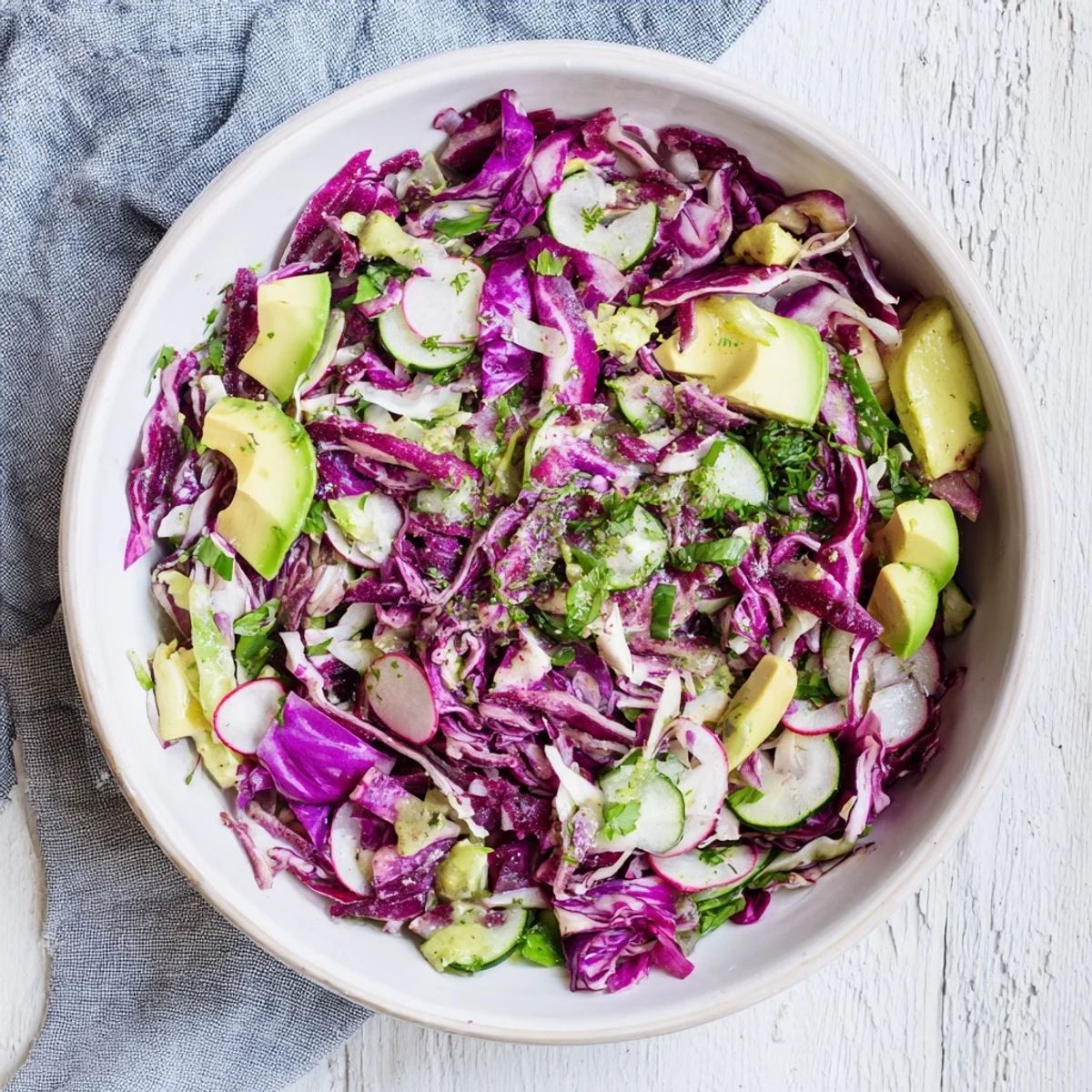 Tossed and ready to serve, a big bowl of Green Goddess Detox Cabbage Salad, a healthy vegan meal.