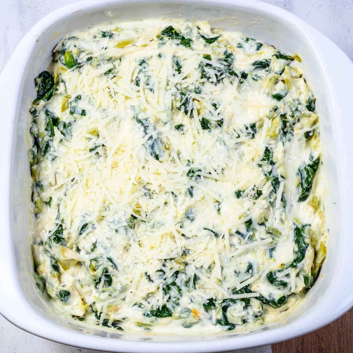 A close-up of creamy Cheesy Spinach Artichoke Dip, rich with melted cheese and artichoke pieces.