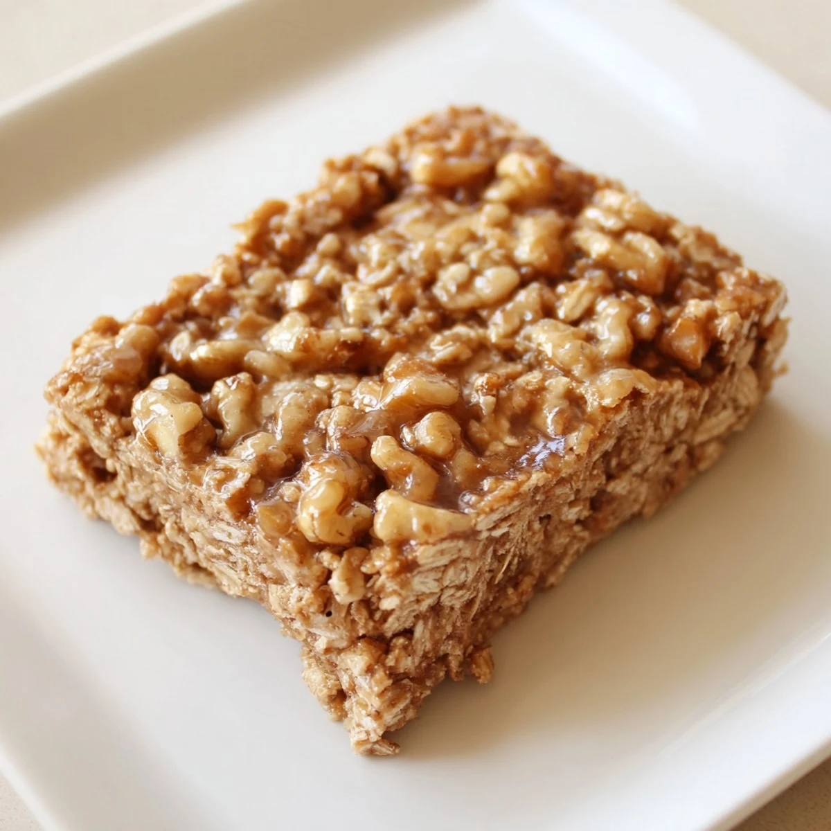Warm, chewy Maple Cinnamon Oatmeal Bars showcasing a delightful texture flecked with nuts and raisins.