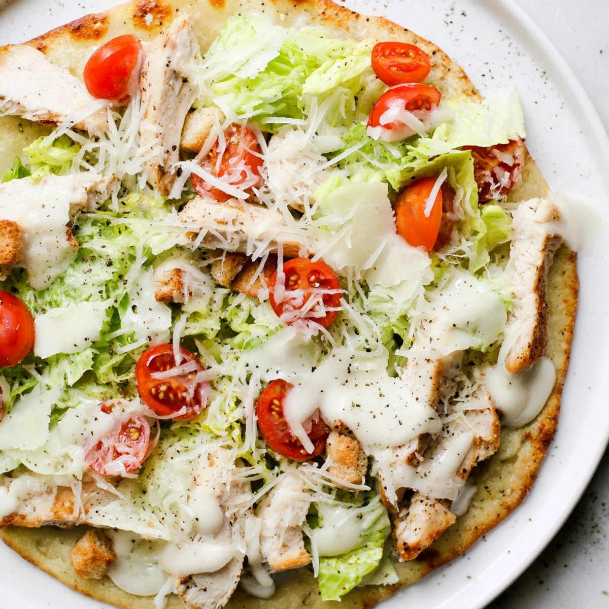 Chicken Caesar Flatbread drizzled with creamy Caesar dressing, piled high with fresh toppings.