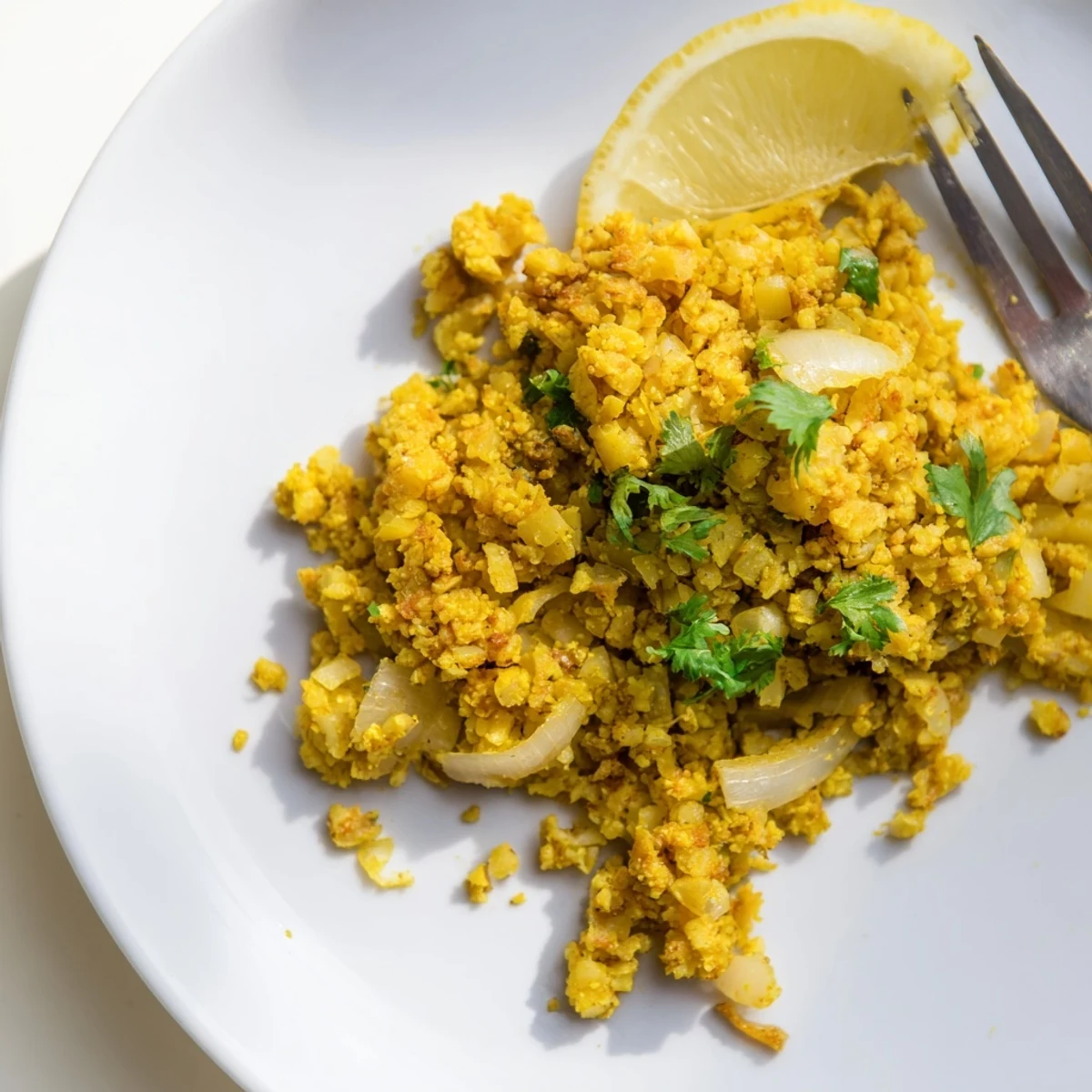 Close-up of fluffy turmeric cauliflower rice, seasoned with cumin and chili flakes, ready to serve.