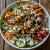 Creamy ranch drizzled over a spicy buffalo chicken bowl with vegetables