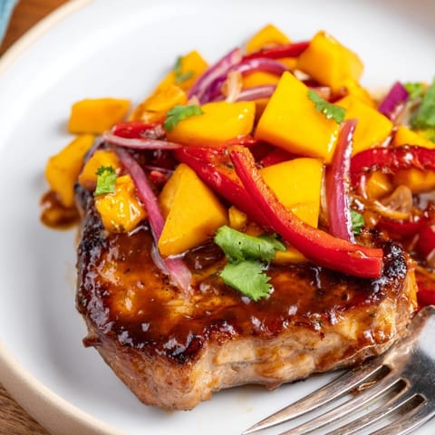 Savory Mango BBQ Pork Chop Bake with tender pork, peppers, and a thick sauce.