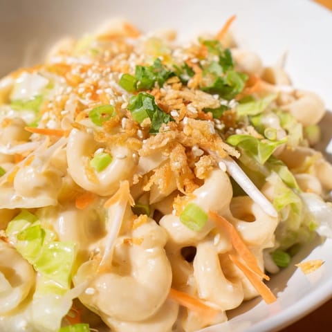 Close-up of Mac and Cheese Egg Roll Stir-Fry: molten cheese, crisp vegetables, comfort food.