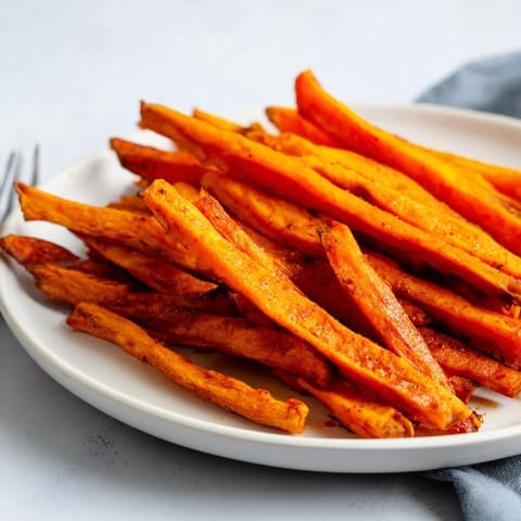 Golden brown baked sweet potato fries served with a zesty yogurt dip, a healthy delight.  