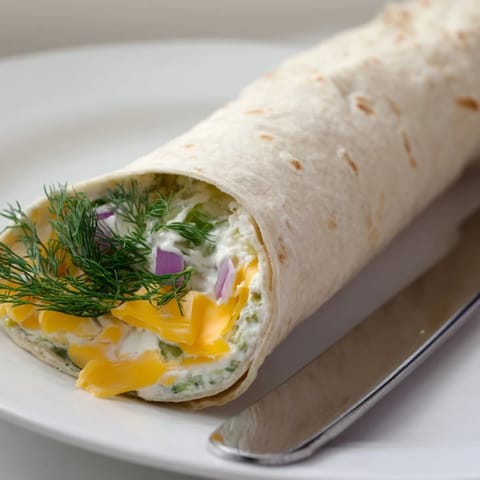 Tangy dill pickles and cheese swaddled in a soft tortilla for Pickle-in-a-Blanket.  