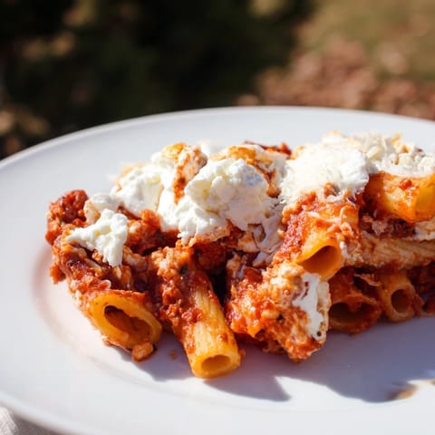 A close-up shot of rich and cheesy slow cooker baked ziti, ready to be served.