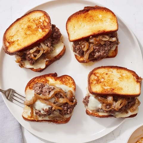 A sizzling cast iron skillet holds a delicious Patty Melt Skillet, ready for a comforting meal.
