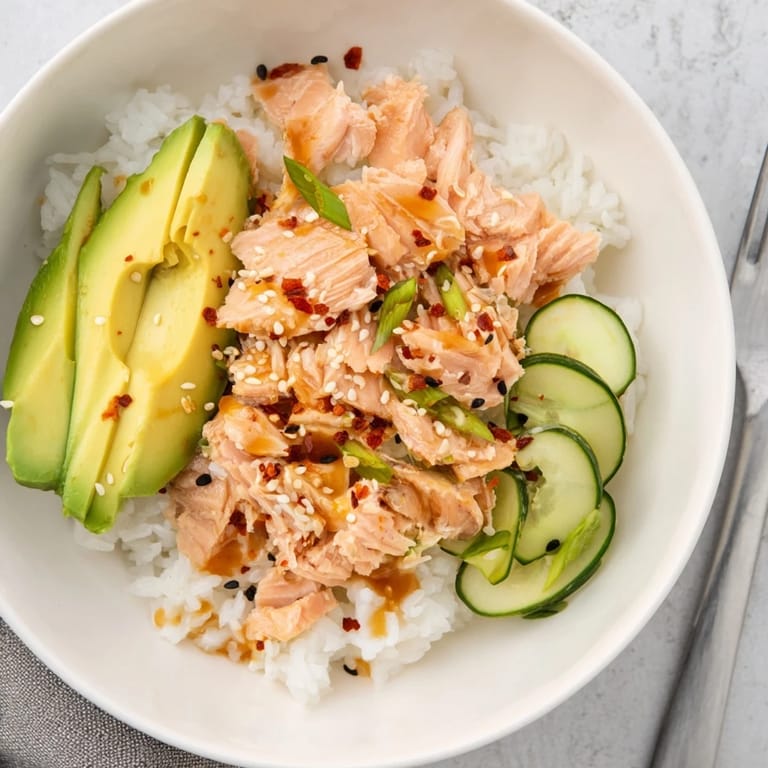 Delicious Leftover Salmon & Rice Bowl drizzled with soy sauce and garnished with scallions.  