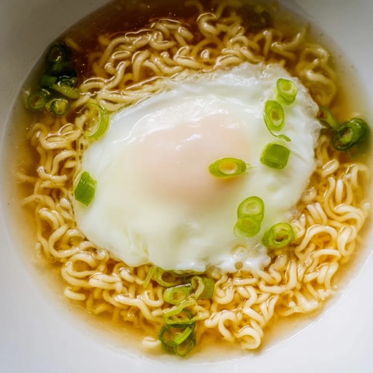 Close-up of the flavorful, buttery broth surrounding the upgraded instant ramen noodles.