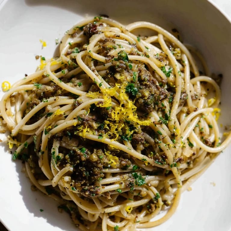 Freshly made Olive Tapenade Pasta, speckled with capers, a vibrant and flavorful vegetarian dinner.