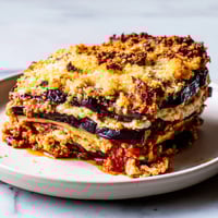 Golden-brown Eggplant Parmesan Lasagna layers with bubbly mozzarella, promising a delicious, cheesy bite.